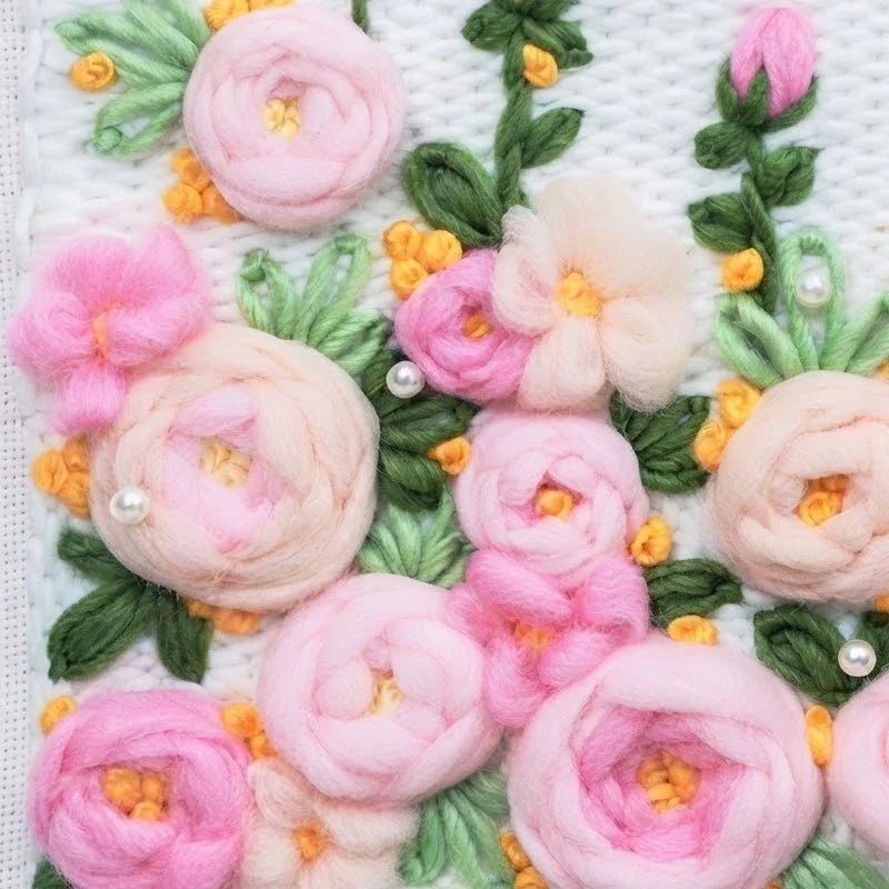 Close-up of pink flower punch needle embroidery from a Calivra Craft DIY material kit.