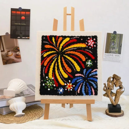 Aurora Kiss DIY embroidery kit featuring colorful firework patterns on a black canvas on an easel