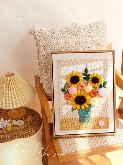 Calivra Craft Cozy Window Sunflower Punch Needle Kit framed on a wooden chair