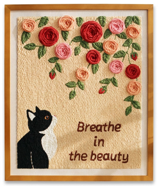 Punch needle embroidery of a black and white cat looking up at colorful roses.