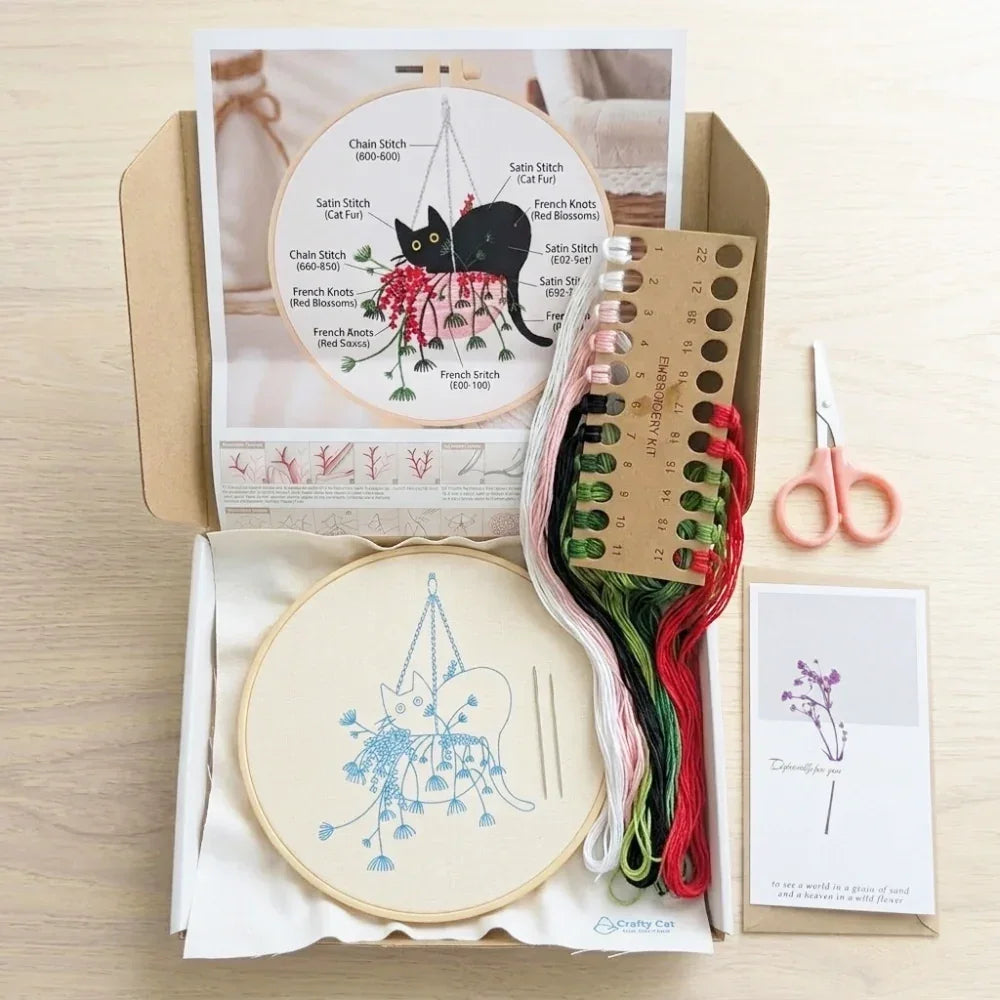 Embroidery kit with cat design, hoop, colorful threads, scissors, and pattern guide.