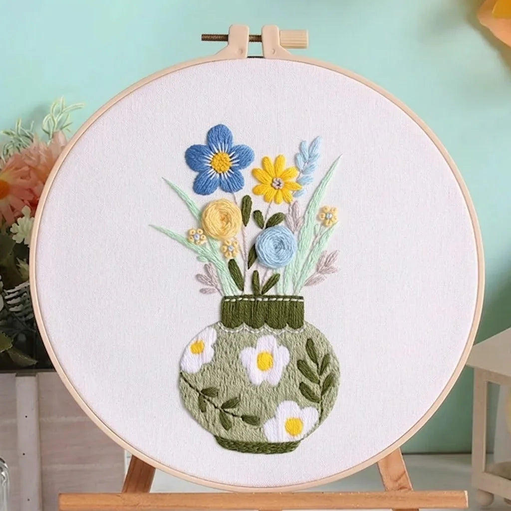Handmade floral embroidery kit featuring colorful flowers in a green patterned vase.