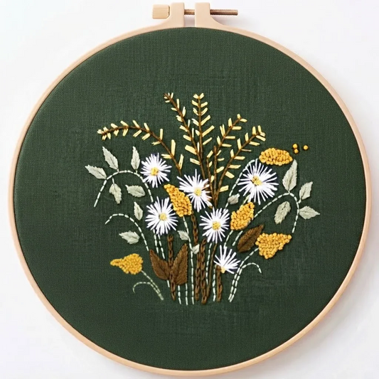 Hand-embroidered floral bouquet on dark green fabric in a wooden embroidery hoop.
