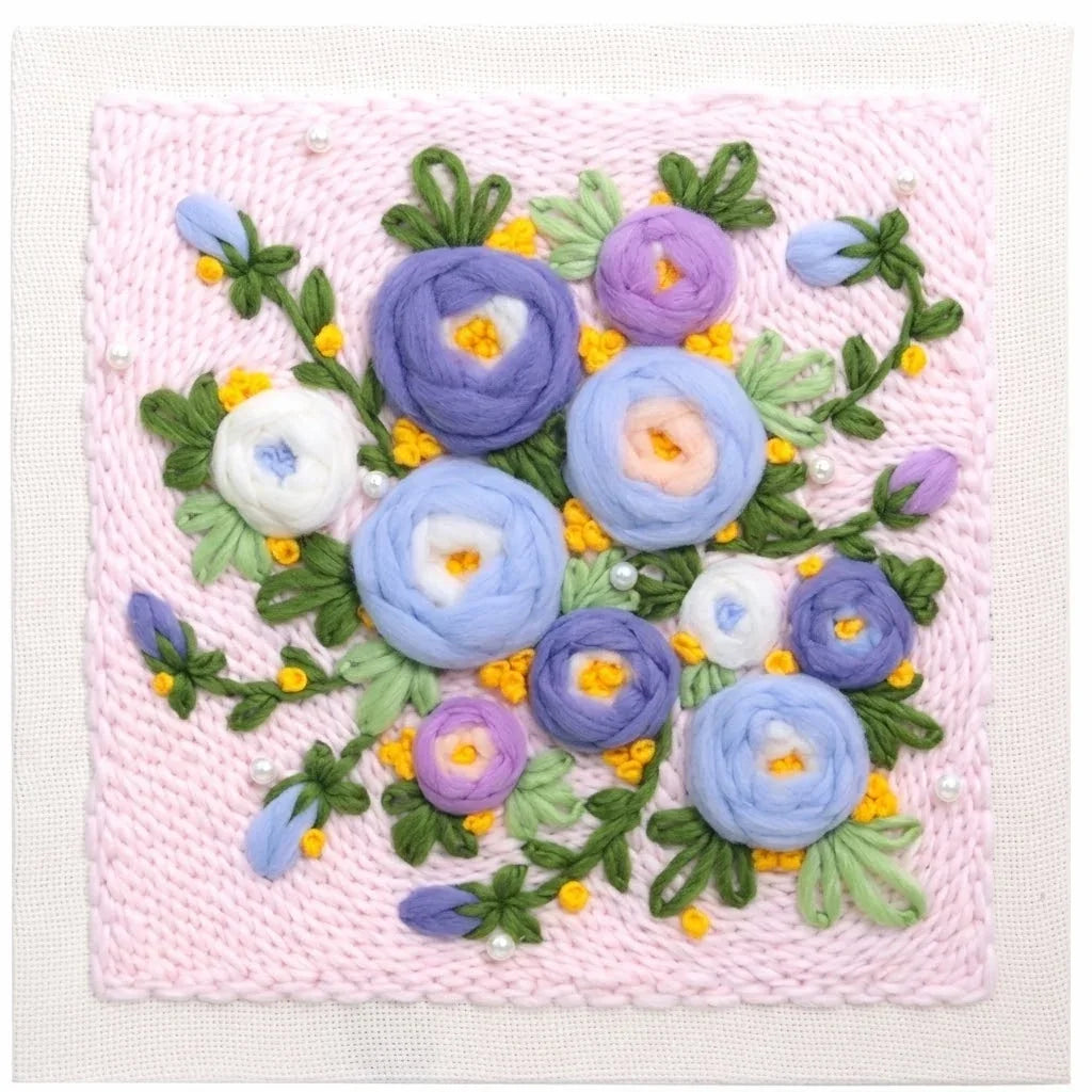 Punch needle embroidery kit featuring a colorful floral pattern on pink yarn.