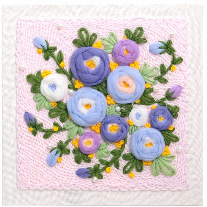 Punch needle embroidery kit featuring a colorful floral pattern on pink yarn.