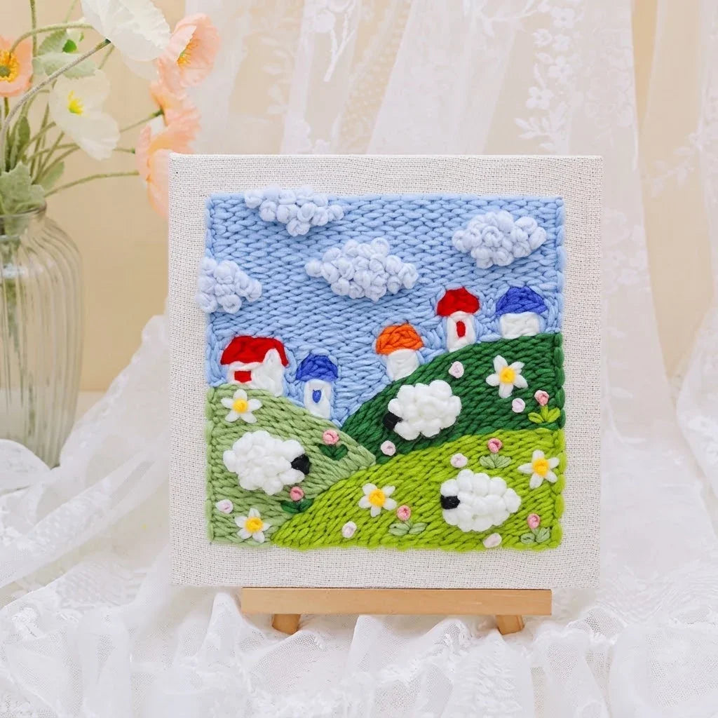 DIY punch needle embroidery kit featuring a colorful landscape with mushrooms and sheep.