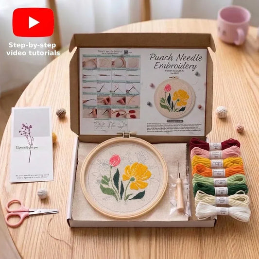 Punch needle embroidery kit with floral hoop, colorful threads, and instructional guide.