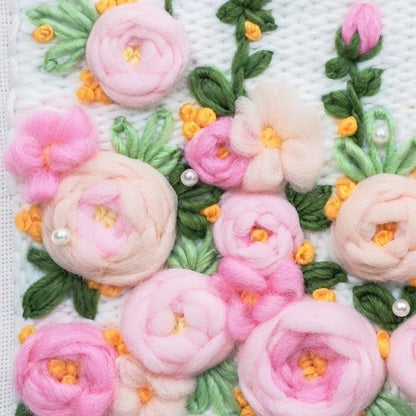 Close-up of pink flower punch needle embroidery from a Calivra Craft DIY material kit.