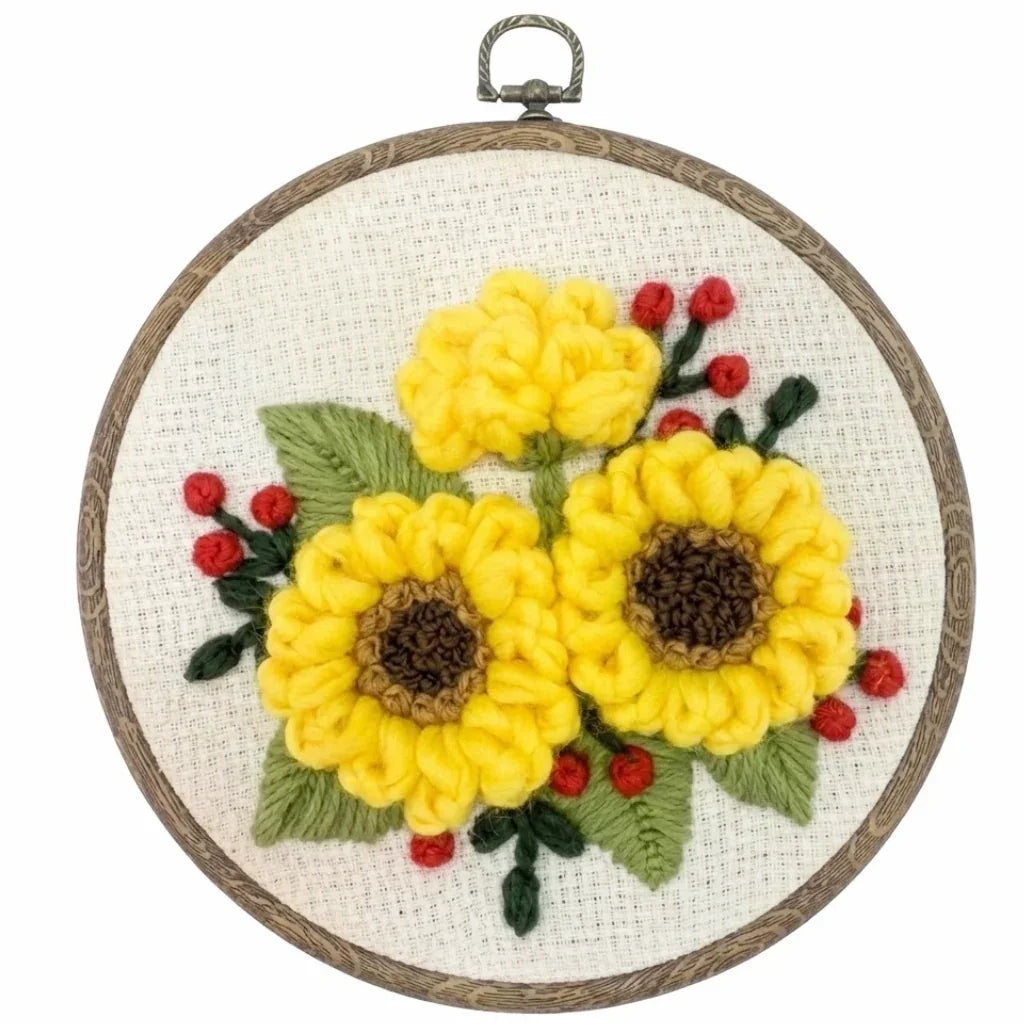 Punch needle embroidery kit featuring three yellow sunflowers with green leaves and red berries.