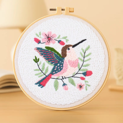 A delicate bird rests among blooming flowers, its wings spread in soft pastel shades.
