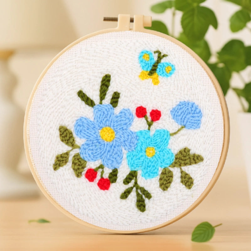 Delicate blue flowers bloom softly against a white canvas, accented by bright red berries and a fluttering butterfly above. The gentle color harmony evokes a sense of calm and freshness — like a quiet whisper of spring in full bloom.