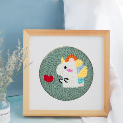 Framed embroidered unicorn with rainbow hair on a light blue background