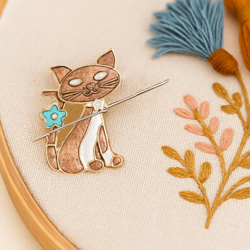 Cat-shaped embroidery pin on a fabric with floral embroidery
