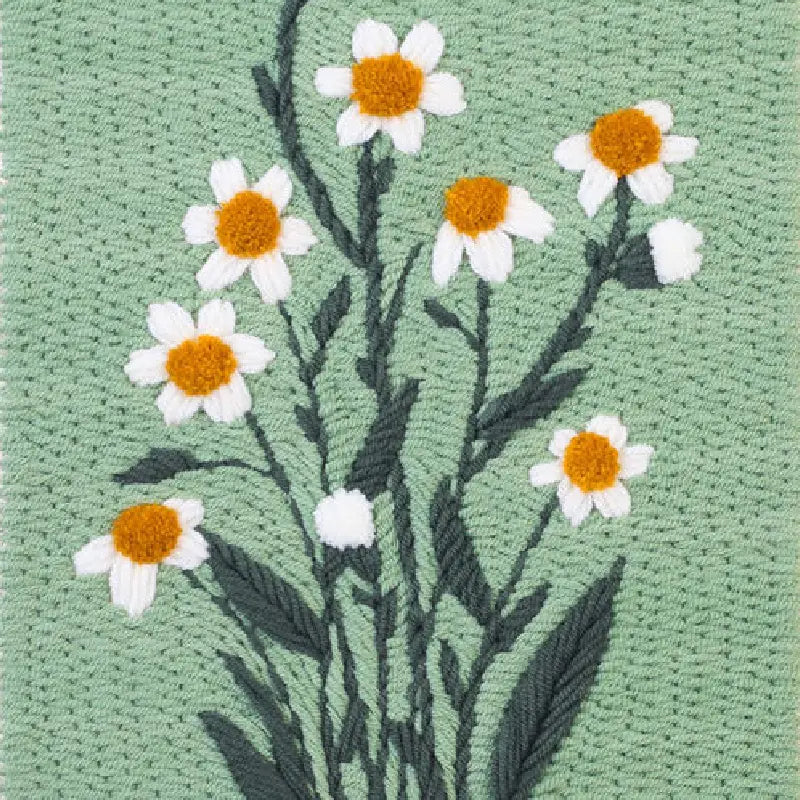 Embroidered design of daisies on a green fabric background