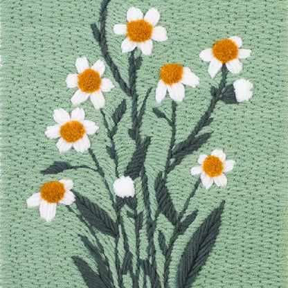 Embroidered design of daisies on a green fabric background