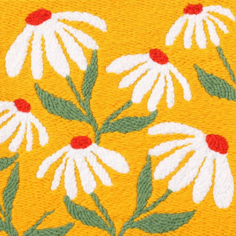 Embroidered pattern of white flowers with red centers on a yellow background