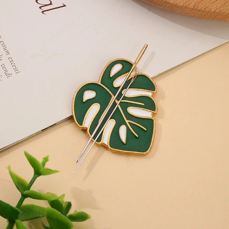 Green leaf-shaped hairpin with gold accents on a beige surface