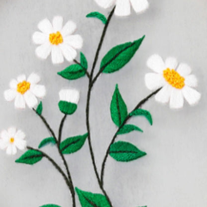Embroidered design of white flowers with yellow centers and green leaves on a gray background