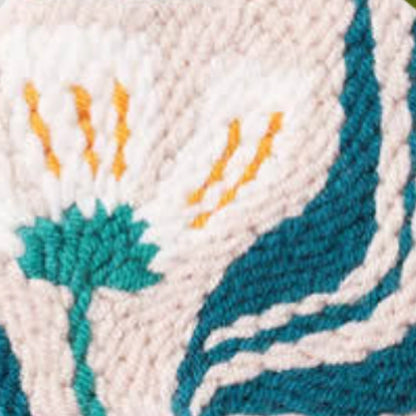 Close-up of embroidered fabric with teal, orange, and white patterns