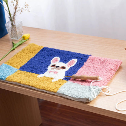 Colorful crocheted blanket with a bunny design on a wooden table.