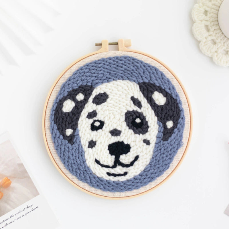 Crocheted dalmatian dog face in a wooden hoop on a light background