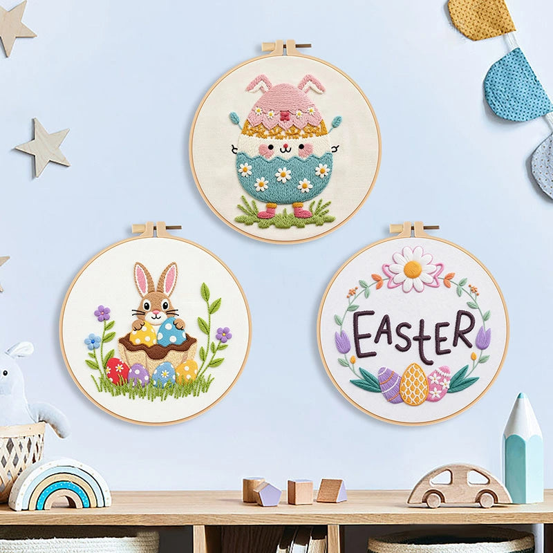 Three embroidered Easter-themed hoop art pieces on a light blue wall.