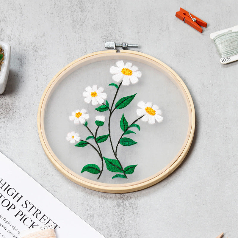 Embroidery hoop with floral design on a gray surface