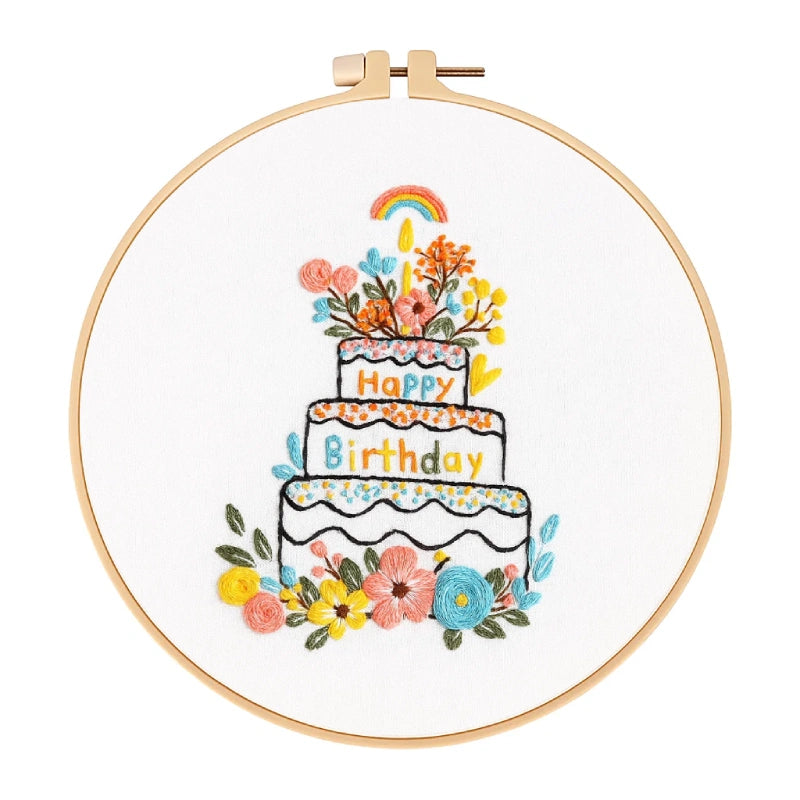 Embroidery hoop with a colorful birthday cake design on white fabric