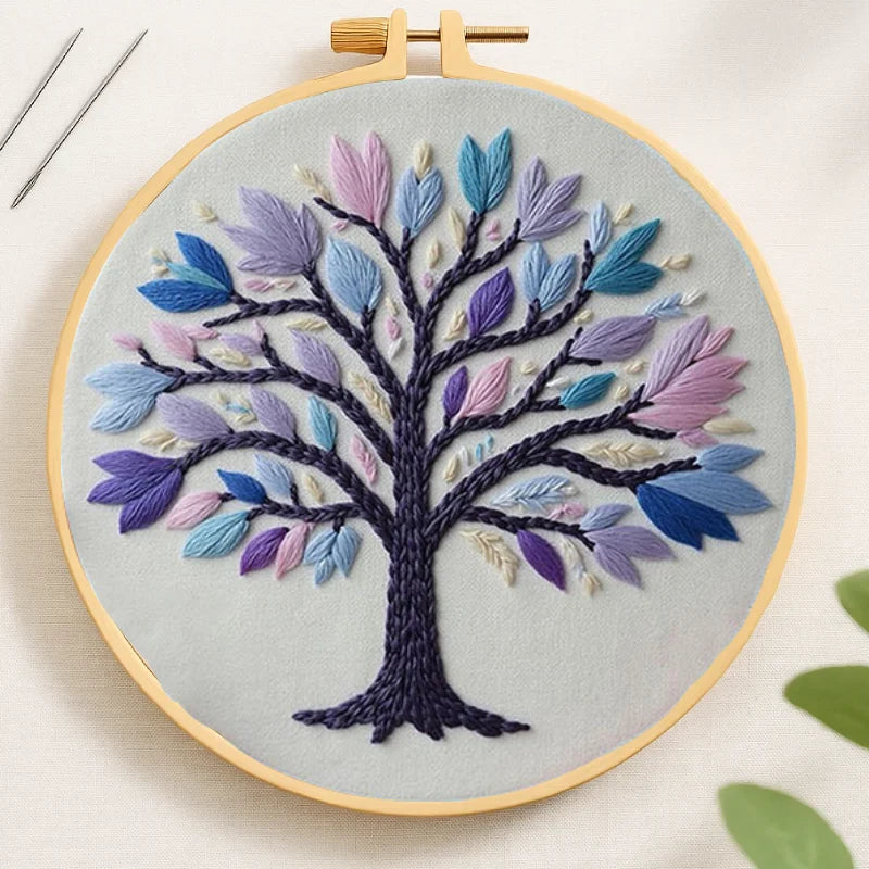 Embroidery hoop with a colorful tree design on a light background