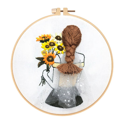 Embroidery hoop with a girl holding sunflowers and brown yarn, on a white background