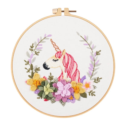 Embroidery hoop with a unicorn and floral design on a white background