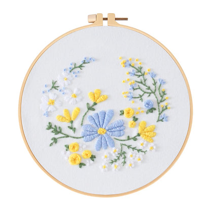 Embroidery hoop with blue and yellow floral design on a white background