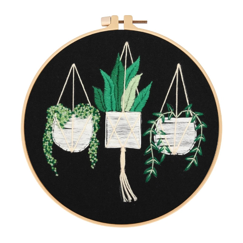 Embroidery hoop with embroidered plants on a black background