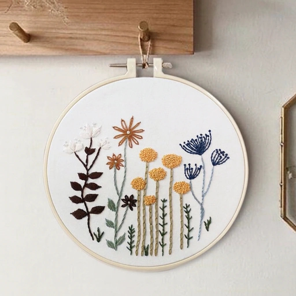 Embroidery hoop with floral design on a white wall