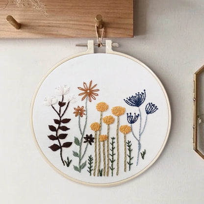 Embroidery hoop with floral design on a white wall