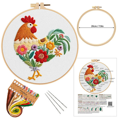 Embroidery kit with a rooster design, hoop, thread, needles, and pattern guide on a white background.
