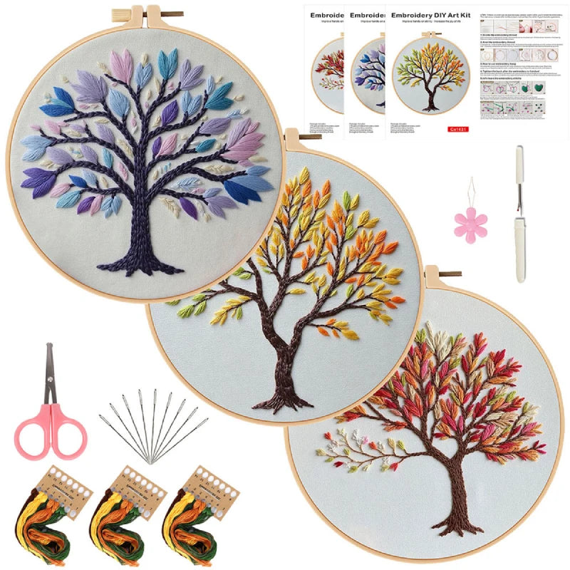 Embroidery kit with three completed tree designs in hoops, tools, and instructions.