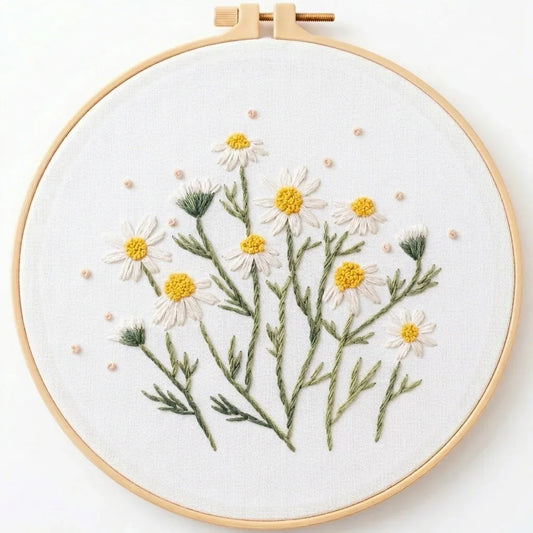 Handmade floral embroidery of white daisies with yellow centers in a wooden hoop.
