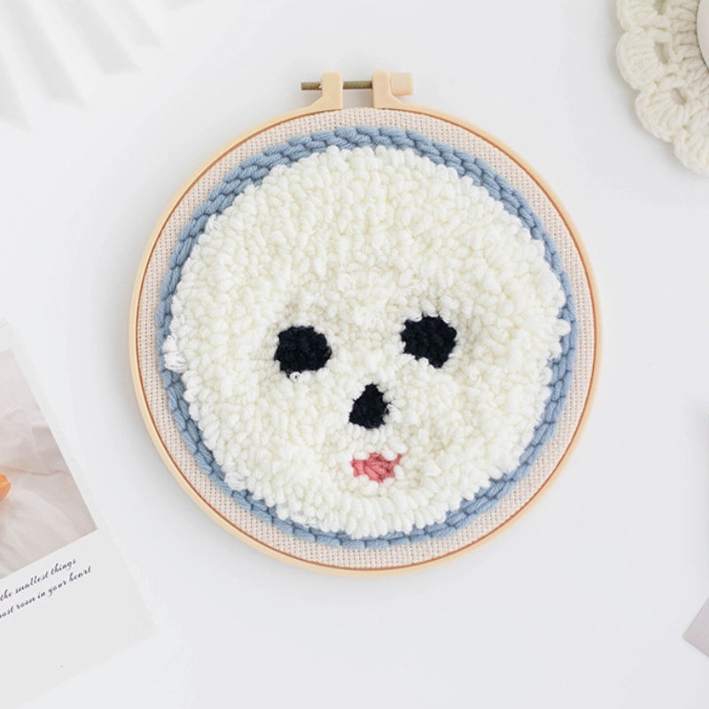 Punch Needle hoop with a completed white face design on a light background