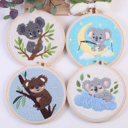 Four embroidered koala designs in wooden hoops on a white background