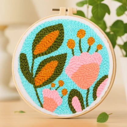 Set against a fresh sky-blue background, soft coral blooms and green-orange leaves dance together like a gentle garden breeze. The lively colors and organic forms capture the essence of nature — vibrant, joyful, and full of life.