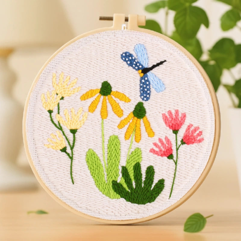 This embroidery design, “Garden Dance,” depicts a blue dragonfly gracefully hovering above bright yellow and pink blossoms. The fresh green leaves and soft pastel tones create a peaceful, nature-inspired composition. With its simple stitches and cheerful colors, it’s a perfect beginner-friendly project that brings a touch of springtime joy to your home or makes a lovely handmade gift.