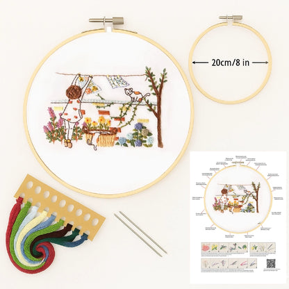 Embroidery hoop with a completed design, embroidery threads, and a diagram on a white background