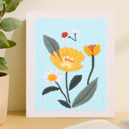 This design features bright yellow blossoms with soft white and orange accents, set against a light blue background that adds a calm and refreshing touch.