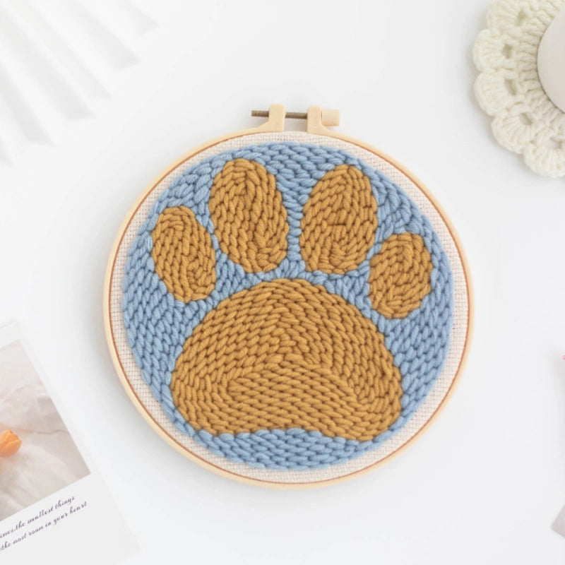 Knitted paw print design in a Punch Needle hoop on a light background
