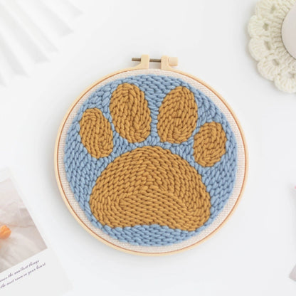 Knitted paw print design in a Punch Needle hoop on a light background
