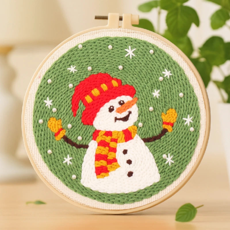This punch needle design captures a cheerful snowman dressed in a red hat and striped scarf, surrounded by gentle falling snow. Its bright colors and playful expression bring warmth and happiness, making it an ideal decoration or handmade Christmas gift.