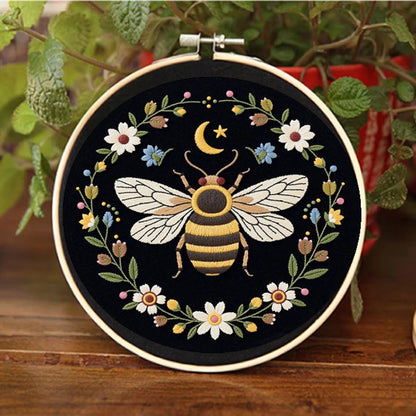 A golden bee rests beneath a crescent moon, surrounded by blooming wildflowers that glow softly against the dark background. This design captures the gentle harmony of nature at night — calm, delicate, and full of quiet beauty.