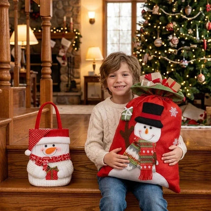 Child holding a red Santa Christmas gift bag with a snowman design near a decorated tree.