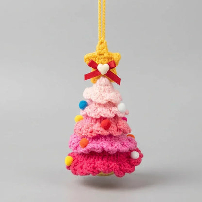 Pink knitted Christmas tree hanging ornament with a star topper and colorful pom poms.